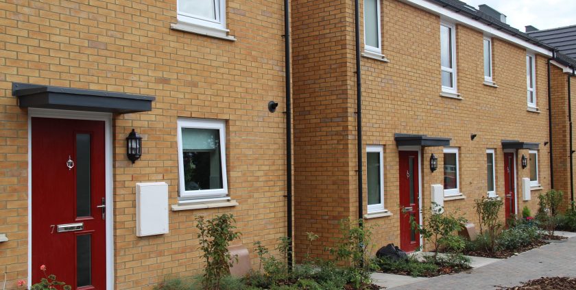 Row of houses with red doors and white Profix windows
