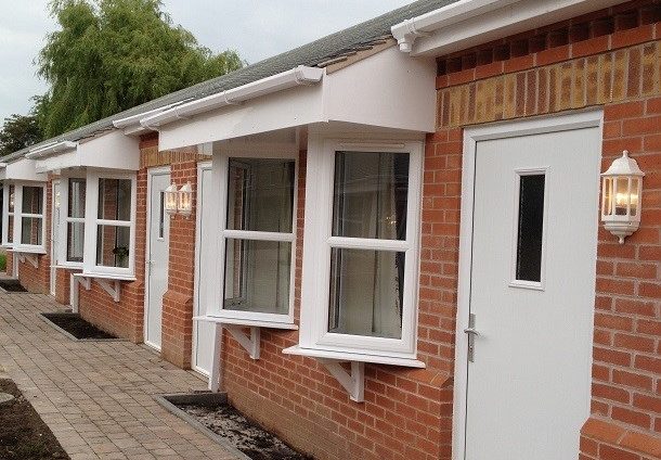 Row of houses with white doors and white thermal efficient Profix windows