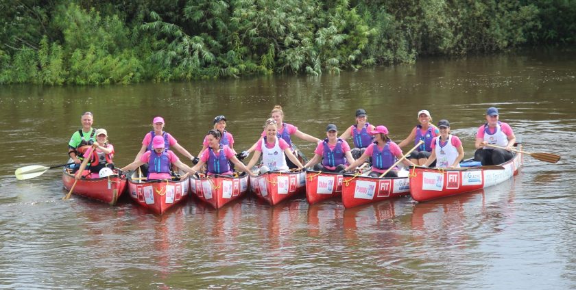 Group of GM fundraisers Paddle2Pedal team pose for picture in canoes